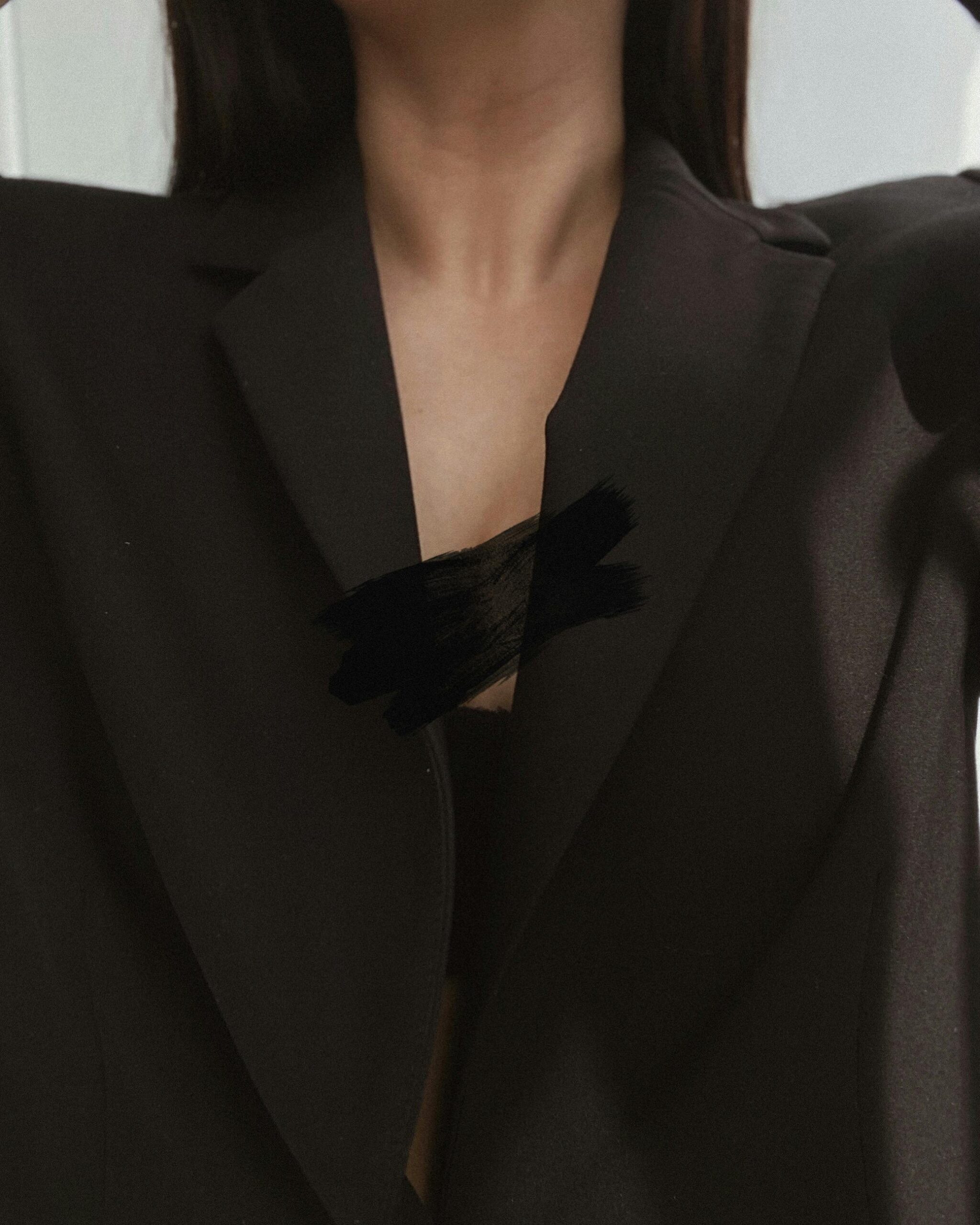 Close-up fashion shot of a woman in a black blazer, highlighting elegant design.